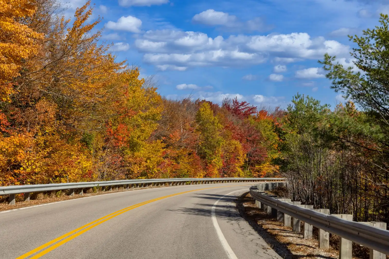 A winding two-lane road through vivid autumn foliage in Franconia, New Hampshire