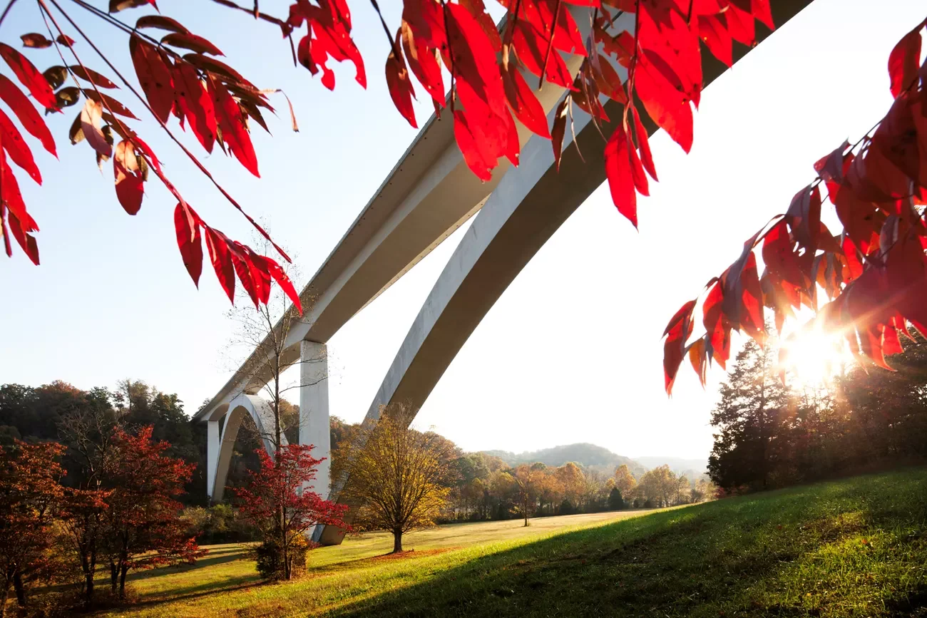 The Double Arch Bridge on the Natchez Trace Parkway framed by red autumn leaves