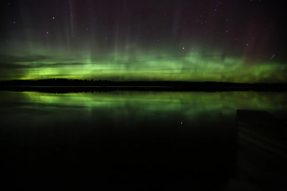 Green northern lights reflected on a still lake at Voyageurs National Park, Minnesota